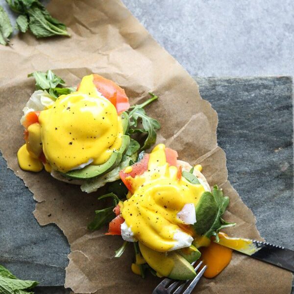 A beautifully plated keto Eggs Benedict with creamy hollandaise, smoked salmon, and microgreens on an almond flour biscuit.